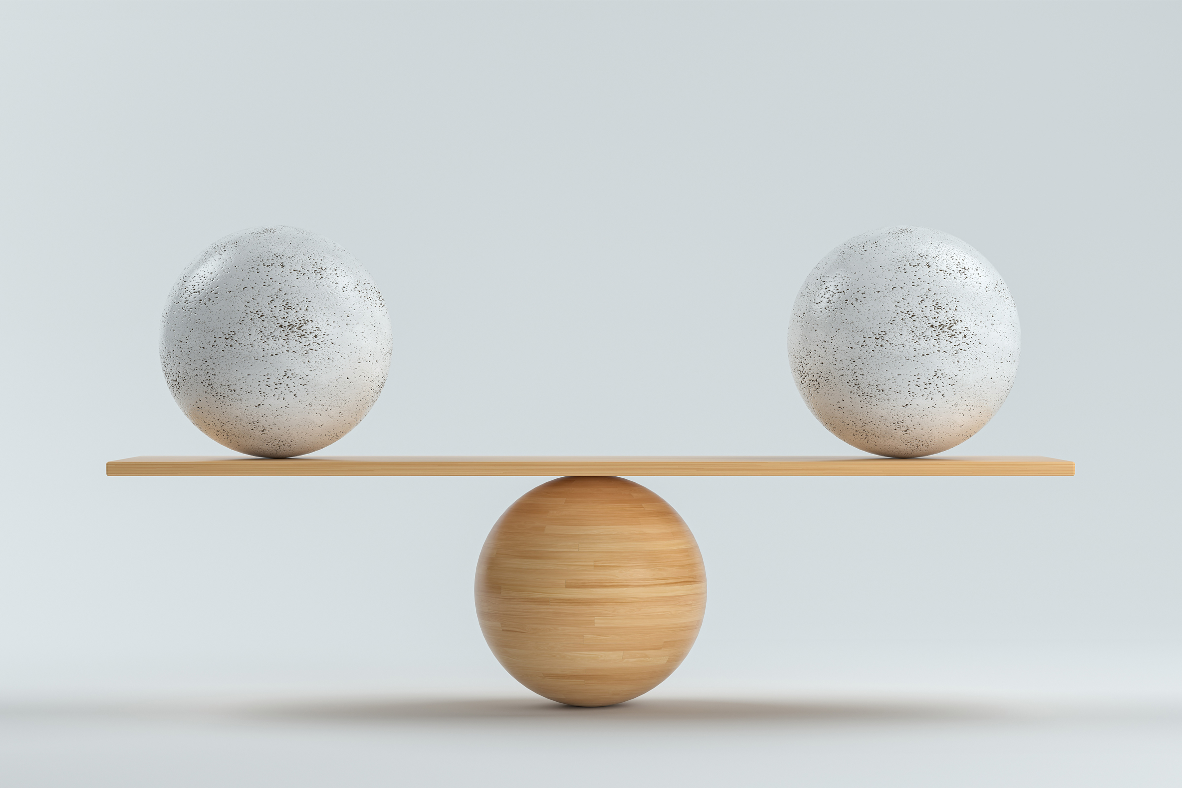 Puinen tasapainolauta, joka tasapainottaa kahta yhtä suurta kivipalloa.