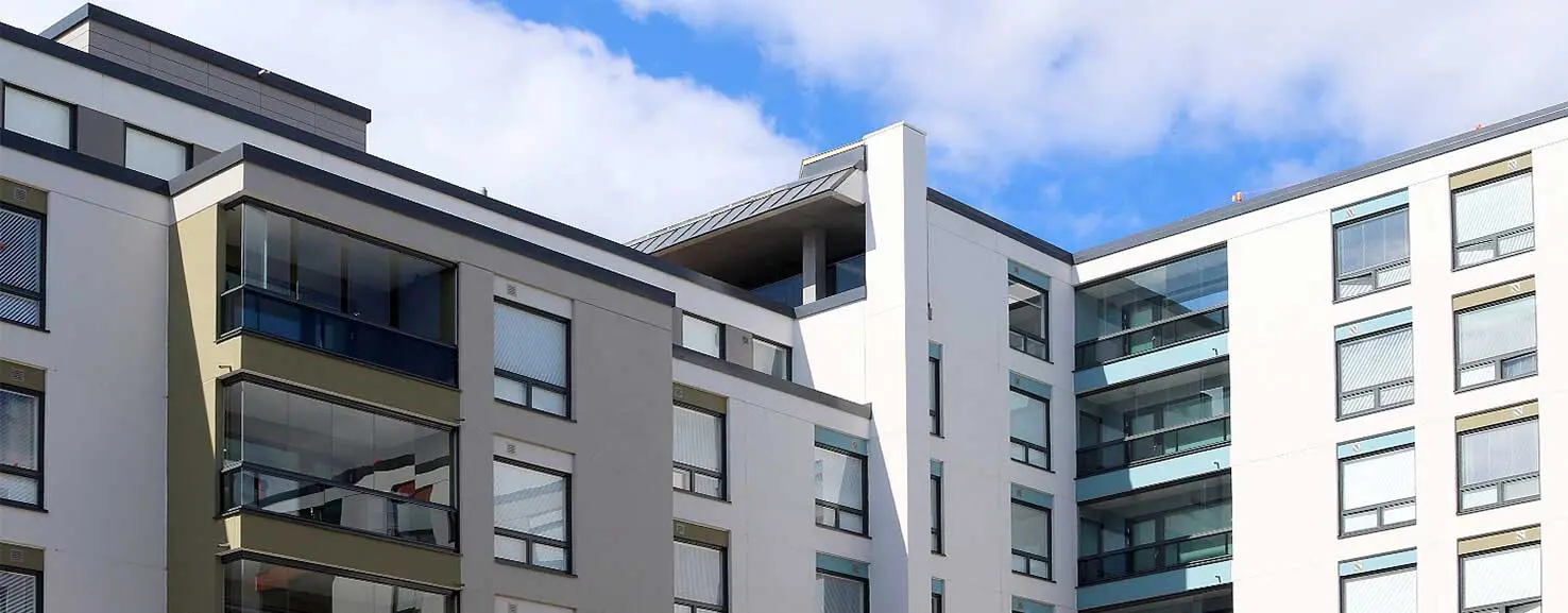 Julkisivu betonikerrostalosta, jossa on paljon parvekkeita ja ulokkeita