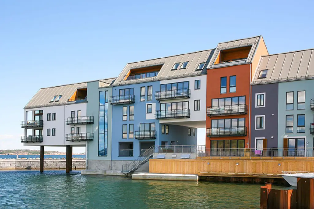 Levyrapattuja asuinkerrostaloja meren läheisyydessä.