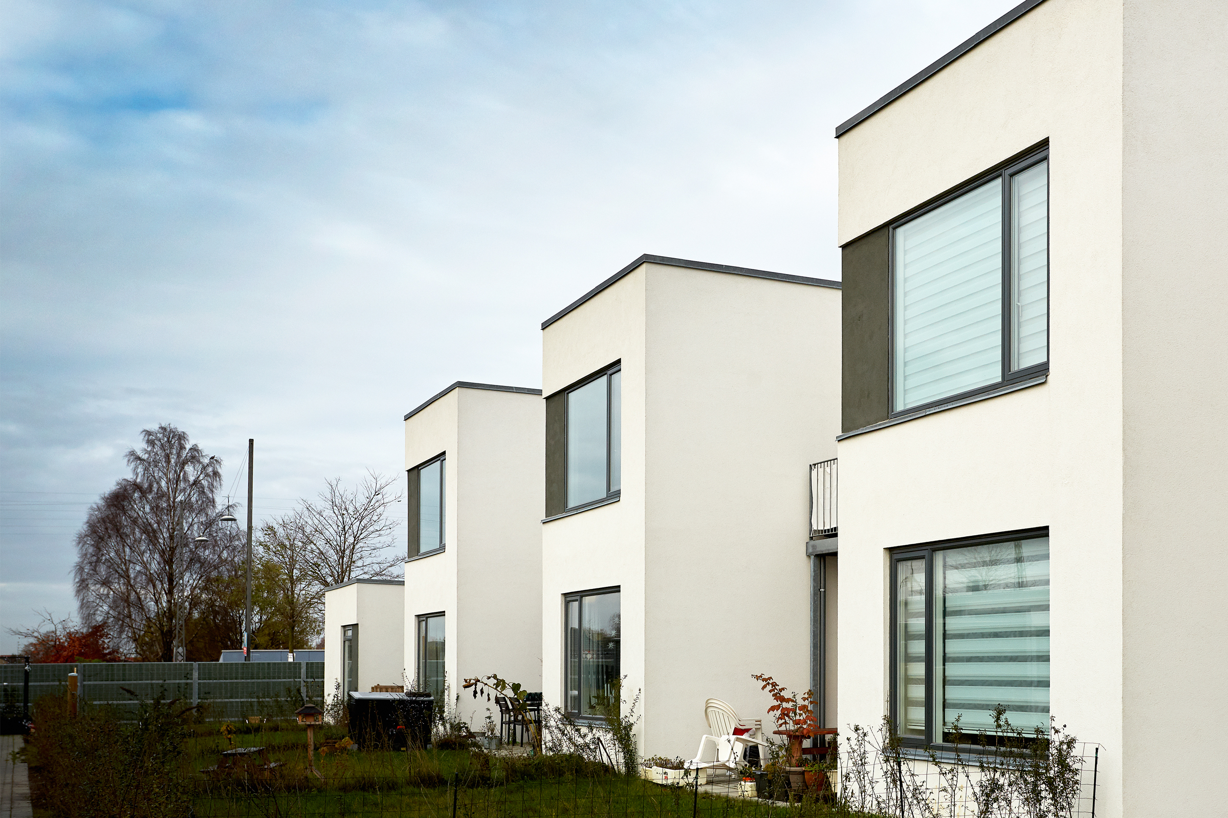 Valkoinen kaksikerroksinen laatikkomainen rivitalo