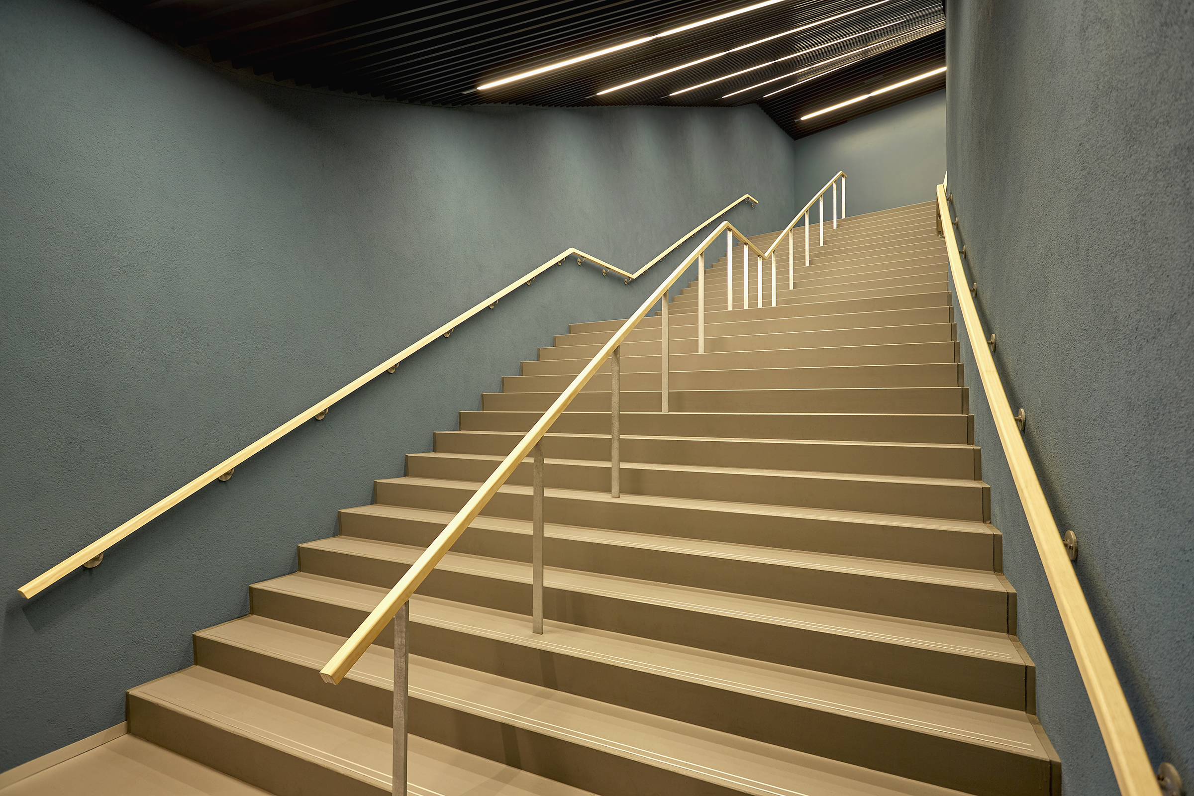 Portaikko, jossa vihreät seinät ja portaat vaaleaa puuta.