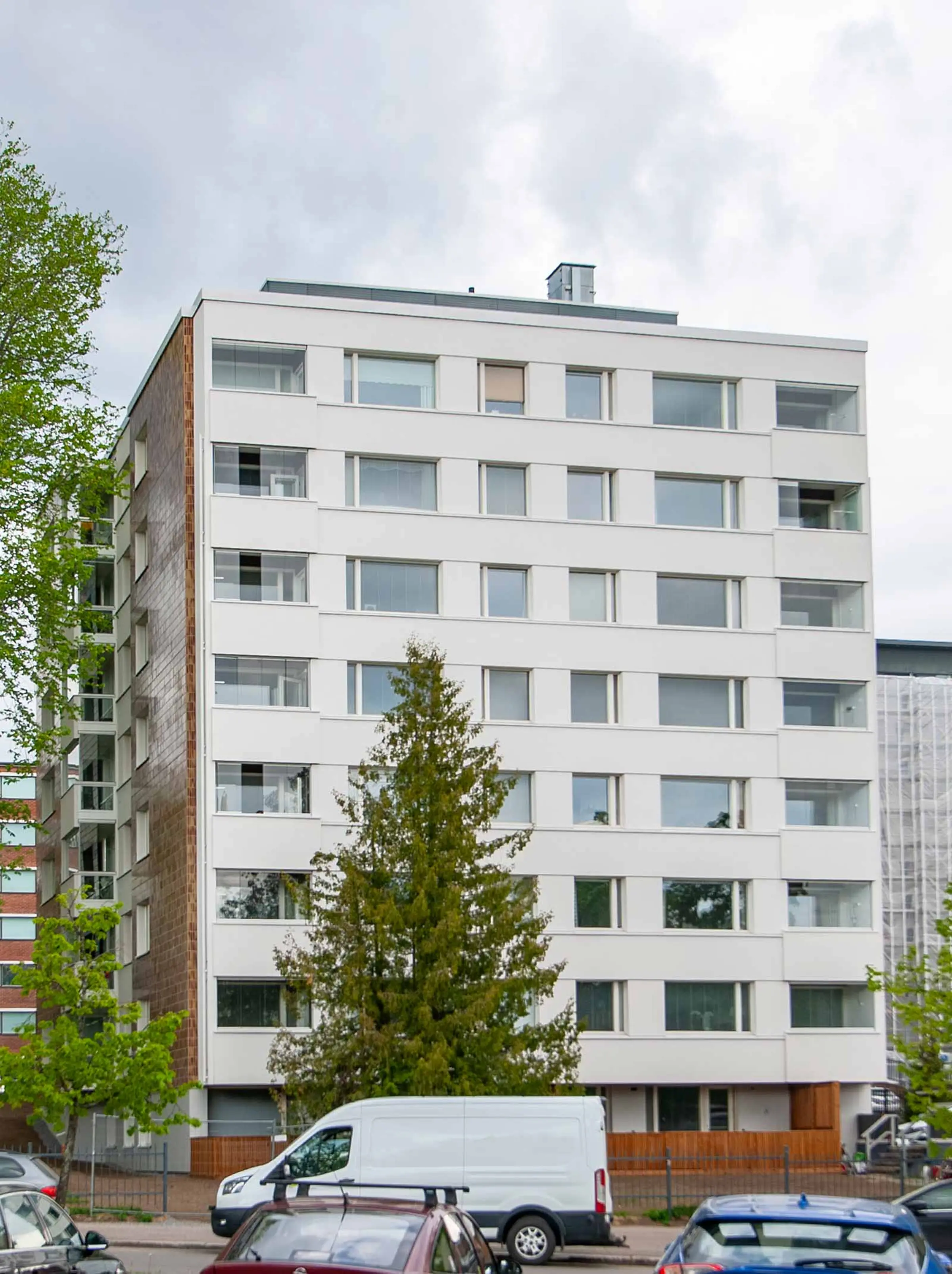 Julkisivukorjattu kerrostalo, jossa keraamista laattaa sekä valkoista rappauspintaa.