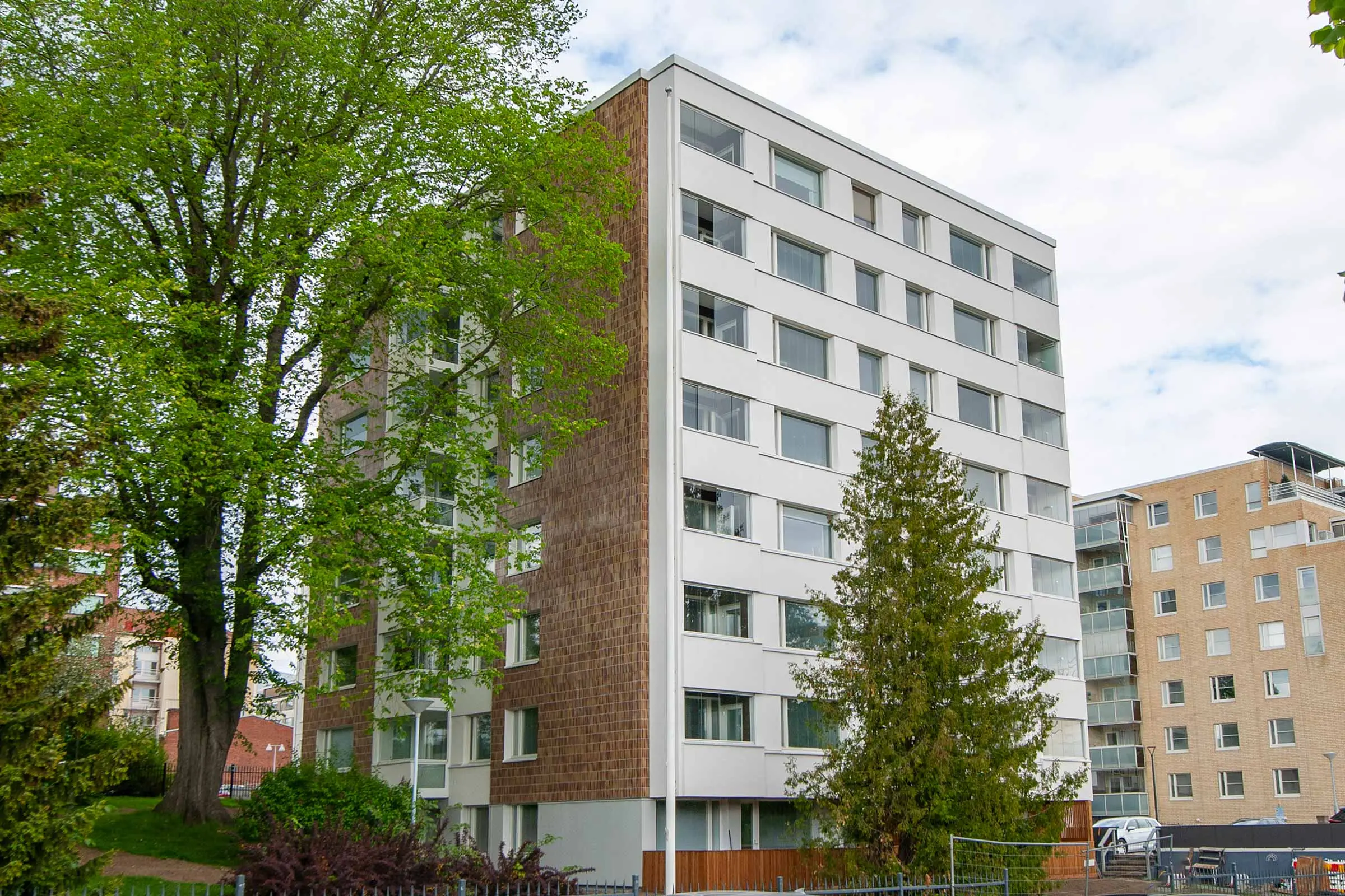 Julkisivukorjattu kerrostalo, jossa keraamista laattaa sekä valkoista rappauspintaa.