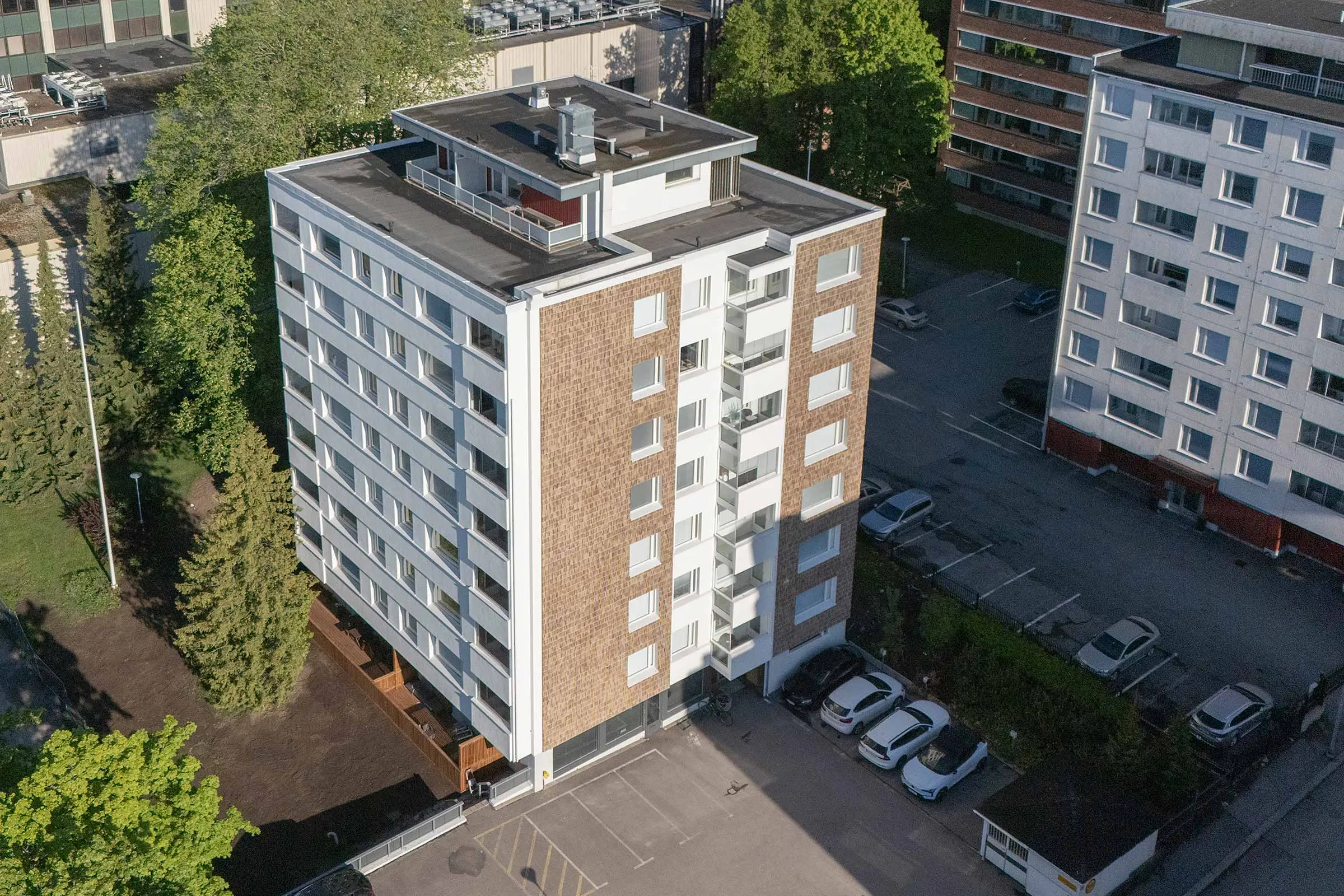 Julkisivukorjattu kerrostalo, jossa keraamista laattaa sekä valkoista rappauspintaa.