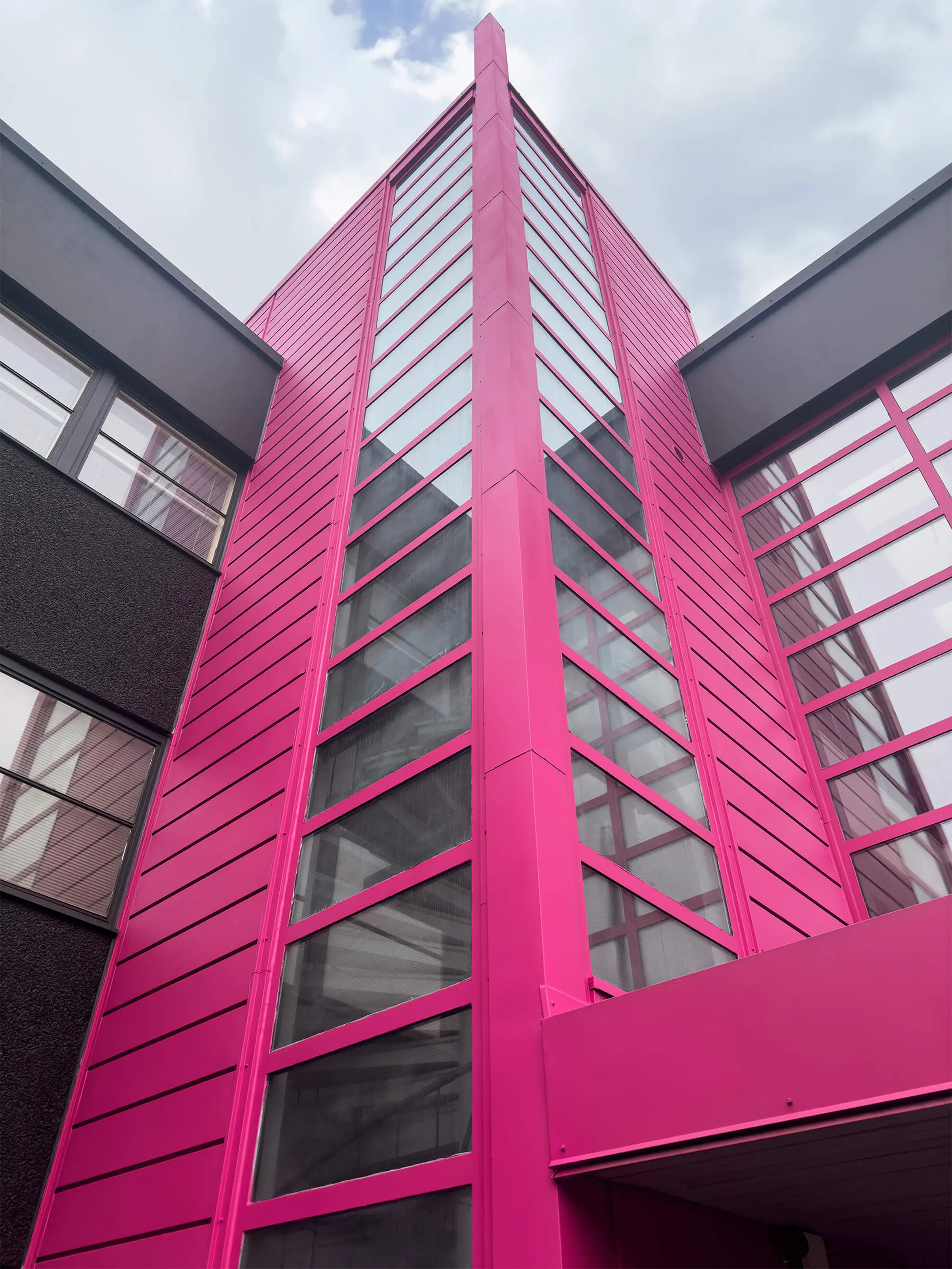 Cityvaraston pinkin värinen rappukäytävä ulkoapäin kuvattuna