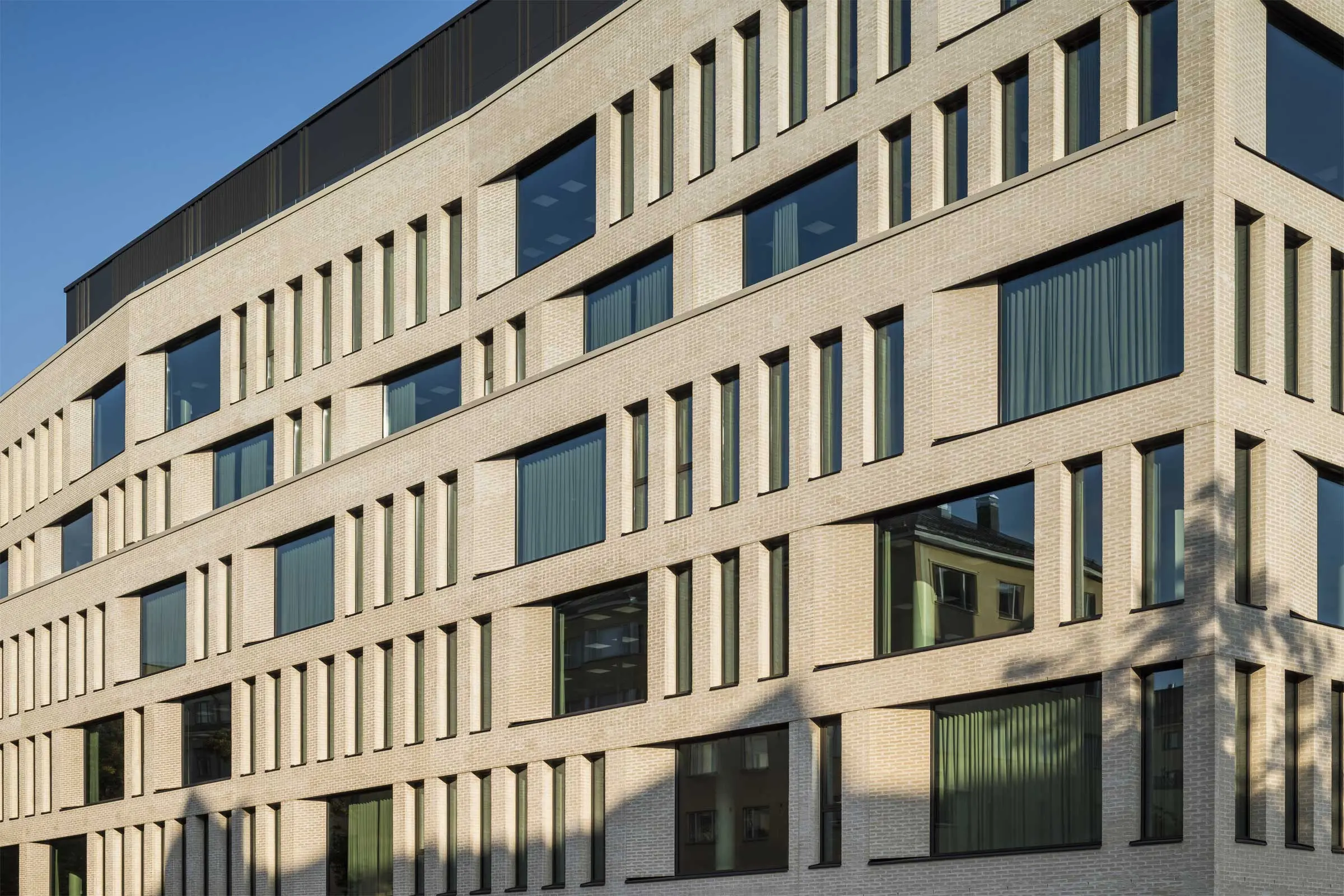 Moderni toimistorakennus vaalealla tiilijulkisivulla