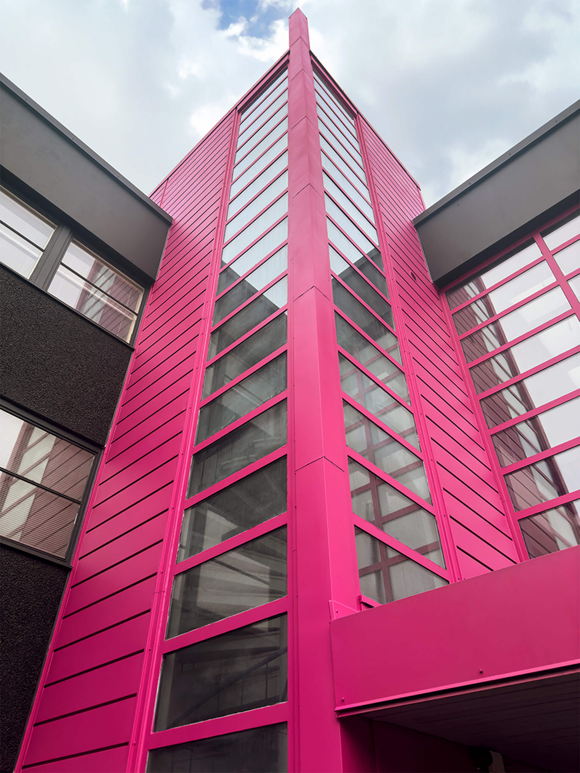 Pinkiksi maalattu ulkoneva porraskuilu.