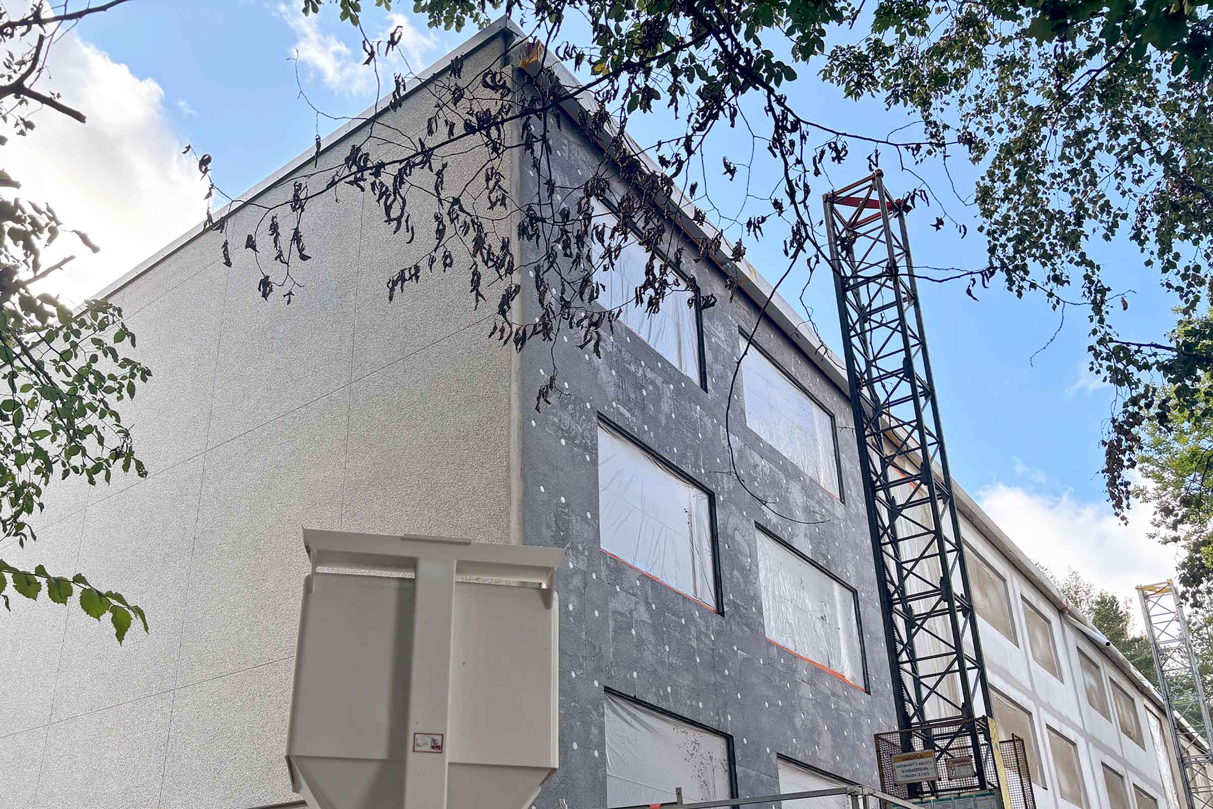 Julkisivukorjauksen eri vaiheita saman rakennuksen ulkoseinissä.