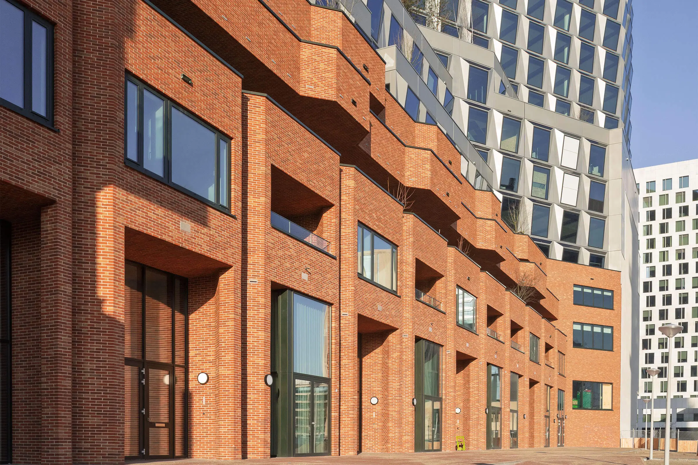 De Puls -rakennuskompleksi tiilimäisellä julkisivulla ja metallisella julkisivulla