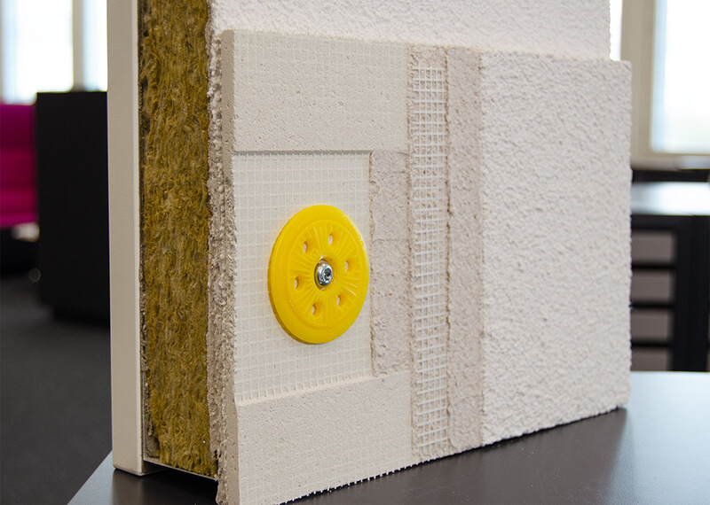 Lähikuva StoReno-järjestelmän mallista, joka on asetettu eristerappausmallin päälle.