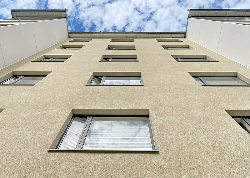 Kerrostalon rapattu julkisivu alakulmasta kuvattuna