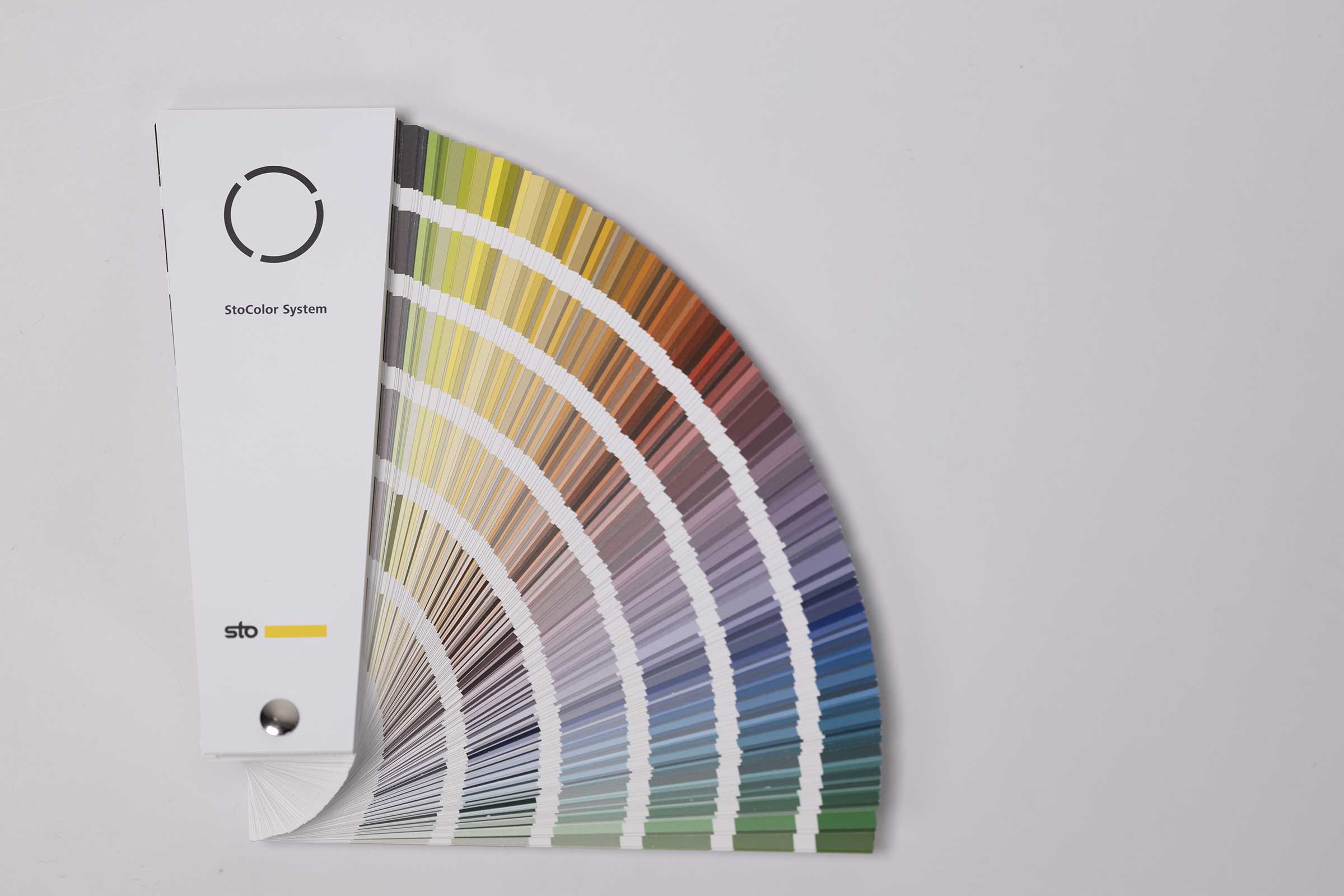 Osittain avoinna oleva väriviuhka josta näkyy kelta-, violetti-, sini- ja vihersävyisiä väriliuskoja