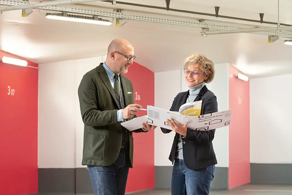 Mies seisoo futuristisen näytön edessä, jossa on erilaisia ​​kaavioita ja animaatioita.